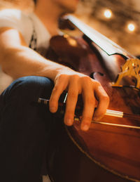 Midsection of man holding cello