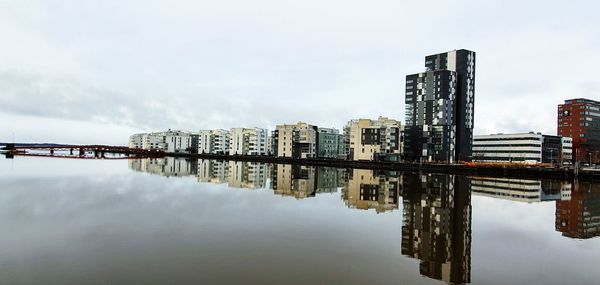 Reflection of buildings in river against sky