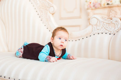 Portrait of cute boy lying on bed at home