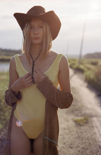 Young woman wearing hat standing on land