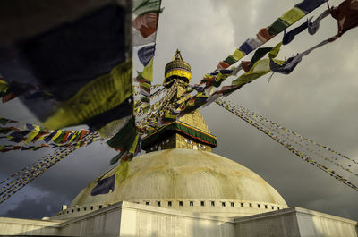 Low angle view of prayer flags and temple against sky