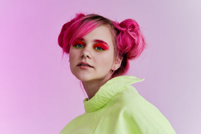 Portrait of young woman against blue background