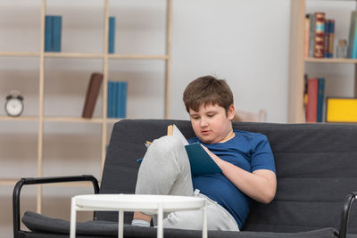 Side view of boy using digital tablet in office