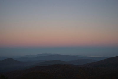 Scenic view of silhouette mountains against sky during sunset