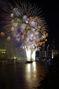 Firework display over river at night