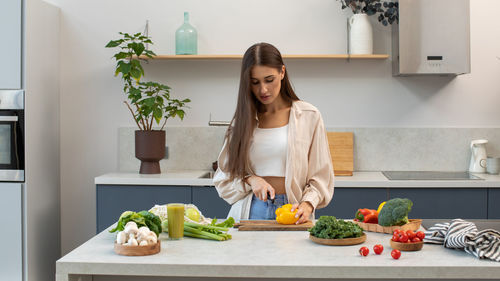 Portrait of young woman using mobile phone at home