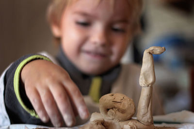 Cute boy playing with playing clay