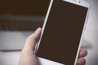 Close-up of hand holding mobile phone