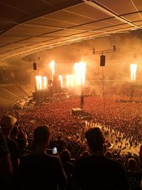 Rear view of people enjoying music concert at night