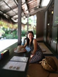 Portrait of smiling woman sitting at table in restaurant