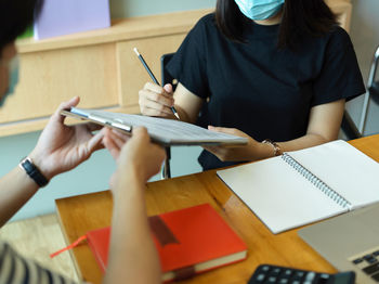 Man giving papers to woman for signing over table