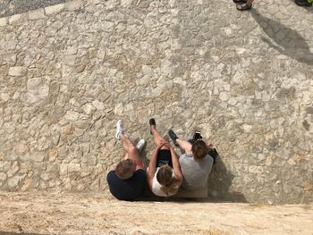 High angle view of women sitting on wall