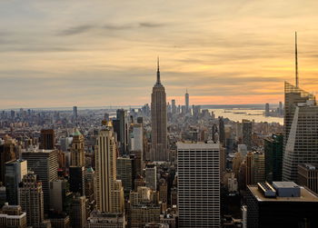 Modern buildings in city against sky during sunset