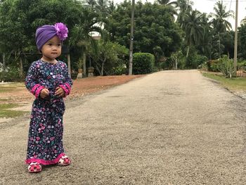 Cute girl standing against trees