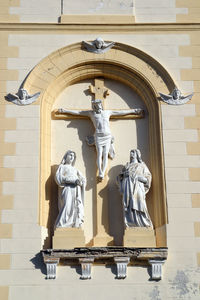 Statue of buddha against brick wall