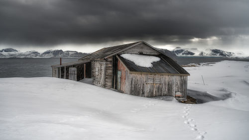 Built structure on snow covered landscape against sky