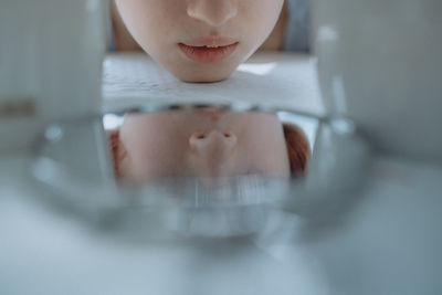 Reflection of woman on mirror at table