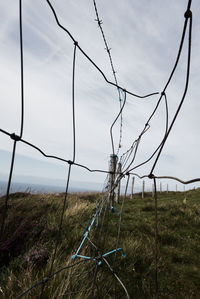 Fence on field against sky