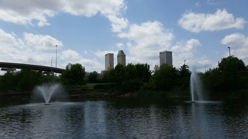 Fountain in city against sky