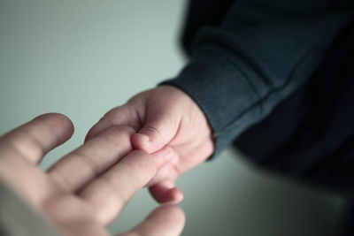 Cropped hand of child holding parent hand