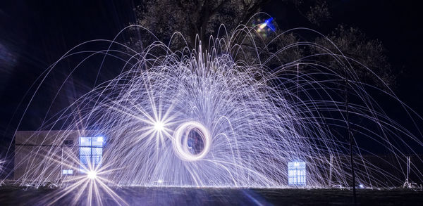 Person spinning illuminated wire wool at night