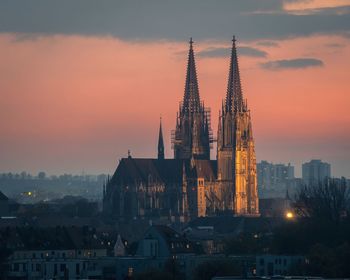 View of illuminated cityscape against sky during sunset