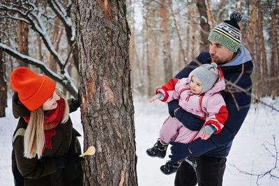 Outdoor family activities for happy winter holidays. happy father and mother playing with little