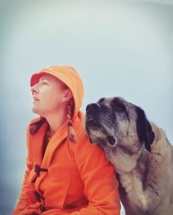 Young woman with dog against clear sky