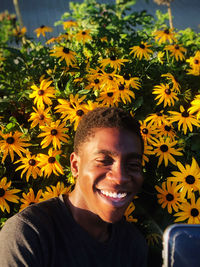 Close-up of smiling man against flowering plants outdoors