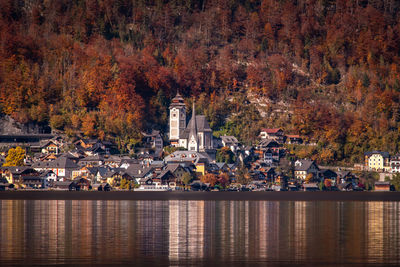 View of buildings by lake during autumn