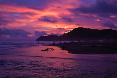 Scenic view of mountains and sea against cloudy sky during sunset