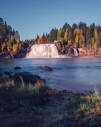 Scenic view of waterfall against sky