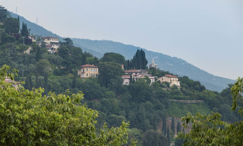 Scenic view of townscape by mountains against sky