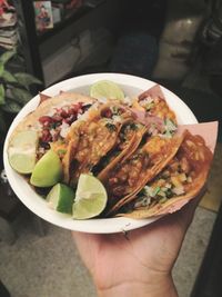 Close-up of hand holding salad in plate