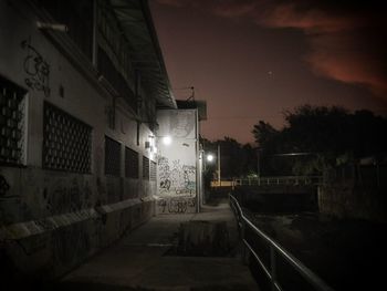 Street amidst buildings against sky at night