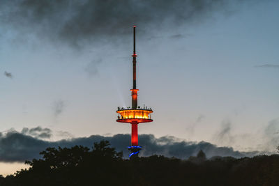 Low angle view of illuminated tower against sky at dusk