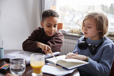 Two boys doing homework at dining table