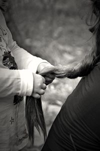 Midsection of girl holding braiding hair