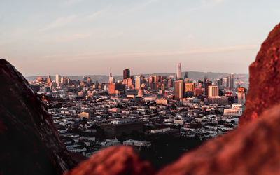 Aerial view of buildings in city against sky during sunset