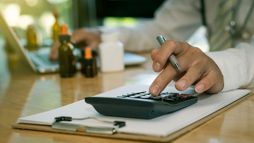 Midsection of man using laptop on table