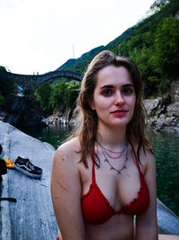 Portrait of beautiful woman standing against water