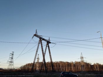 Electricity pylon on field against clear sky