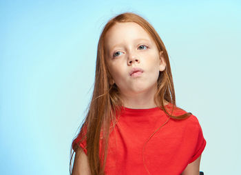 Portrait of young woman against blue background