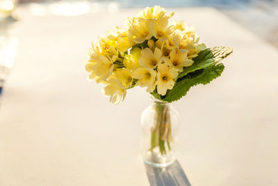 Close-up of yellow flower vase on table