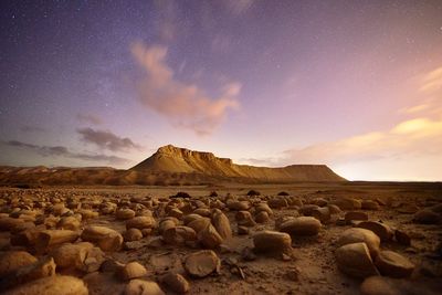 Scenic view of arid landscape against sky during sunset