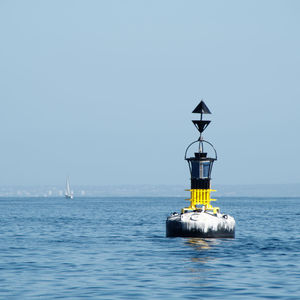 Lighthouse on sea against clear sky