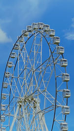 Low angle view of ferris wheel against clear blue sky