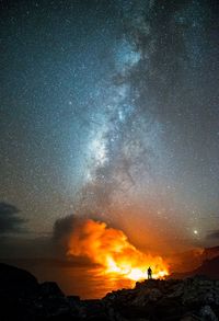 Lava over sea against star field at night