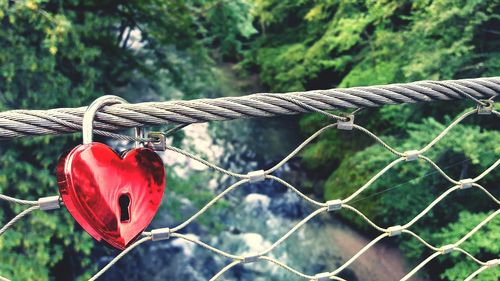 High angle view of red heart shape love lock on bridge over river