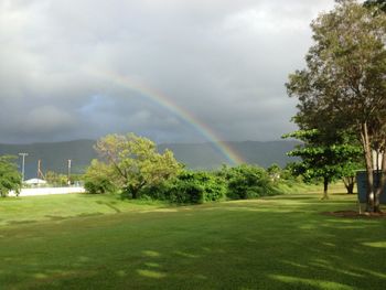 Scenic view of field against rainbow in sky